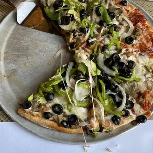 Small veggie pizza with sausage on half.