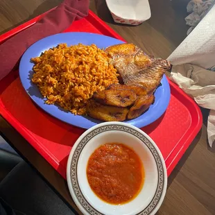 Fried fish with jollof rice, and some sort of salsa on the side