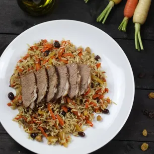 a plate of rice with meat and carrots