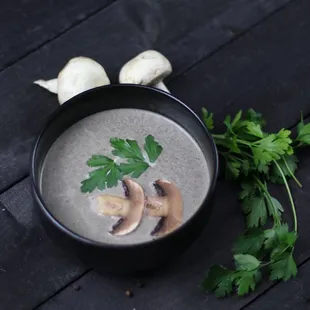 a bowl of soup with mushrooms and parsley