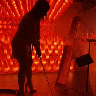 a woman putting a golf ball into a hole