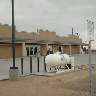 a gas tank in front of a gas station