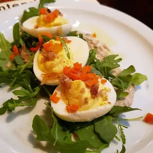 a plate of deviled eggs on a bed of greens