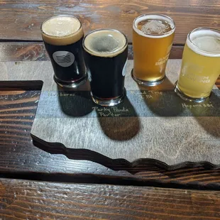 a flight of beers on a slate board