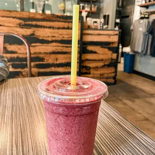 a smoothie in a plastic cup with a straw