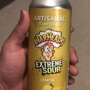 a hand holding a can of lemon