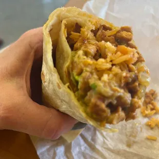 a hand holding a burrito