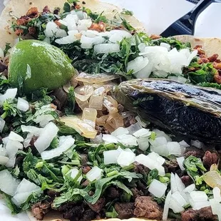 a plate of tacos with meat and onions