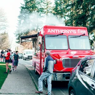 a red food truck parked on the side of the road