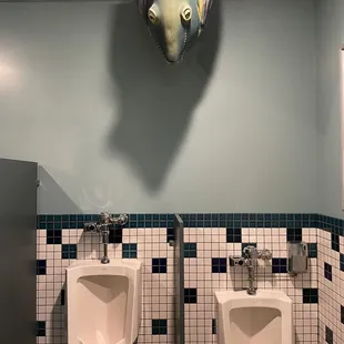 Fish staring directly at you from above the bathroom urinal.