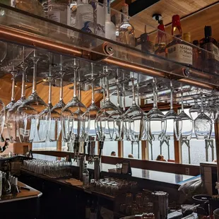 a bar with wine glasses hanging from the ceiling