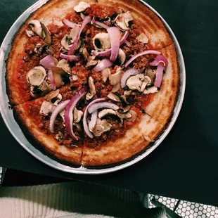 Gluten free thin crust pizza with bacon, onion, and mushroom