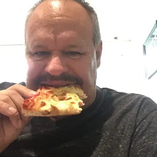 a man eating a slice of pizza