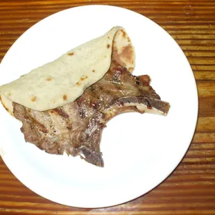 ows a piece of steak and a burrito on a plate
