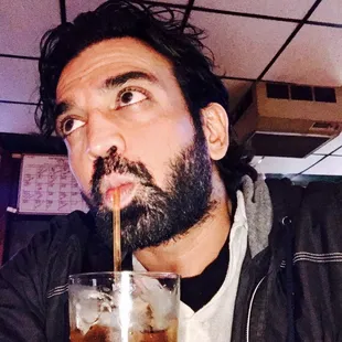 a man drinking a drink with a straw