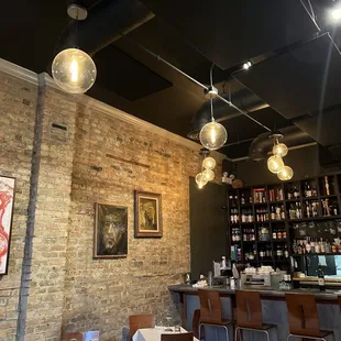 a bar with a brick wall and bar stools