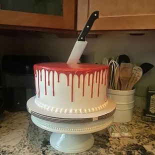 a knife sticking out of a drip cake