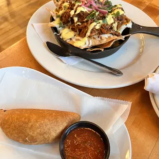 a plate of nachos and a bowl of salsa