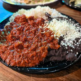 Plate of refried black beans, rice, and chorizo that came with the Molcajete El Monstruo ($40).