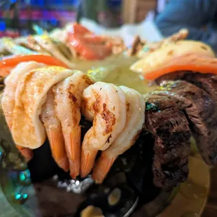 Molcajete El Monstruo. $40. Steak, grilled chicken, chorizo, grilled shrimp, green onion, grilled queso fresco, tomato, cactus, and more.