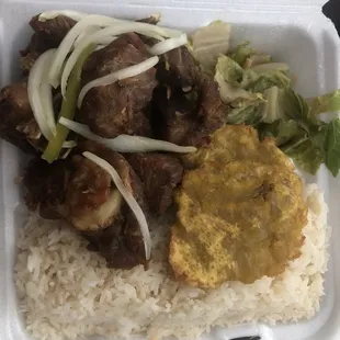 Fried Turkey with white rice, beans, fried green plantain &amp; pickliz (not pictured). Salad wilted with heat from food.