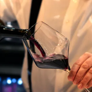 a man pouring a glass of red wine
