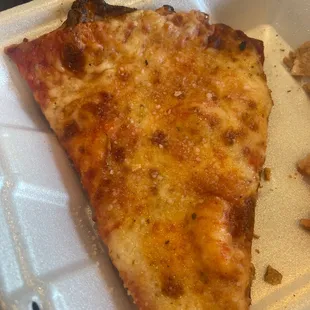 a slice of pizza in a styrofoam container