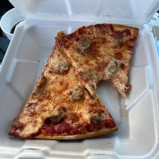two slices of pizza in a styrofoam container