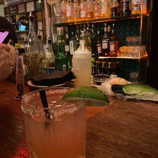 a glass of cocktail on a bar
