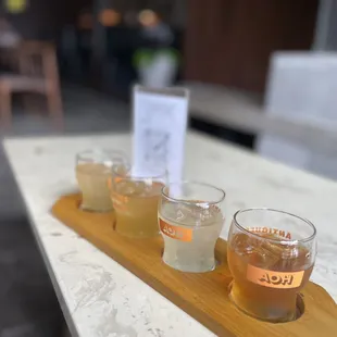 four glasses of beer on a wooden tray