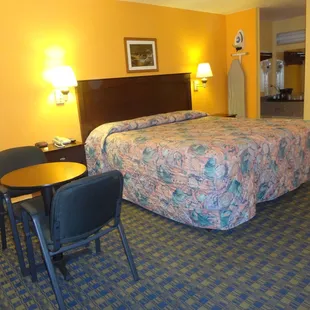 Single Room with a King Bed. All rooms have an iron, ironing board, table and chairs, lamps, and telephone.