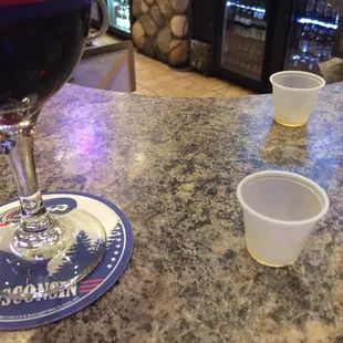 a glass of red wine and two cups