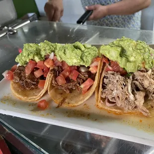 three tacos with guacamole