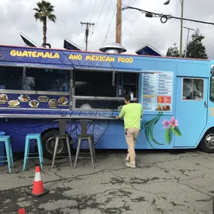 a woman standing in front of a food truck