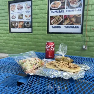 a table with a sandwich and soda
