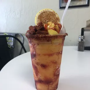 VIP - A mango sorbet layered with chamoy and Tajín, topped with spicy candy, fresh diced mango, lemon slice and tamarind candy stick.