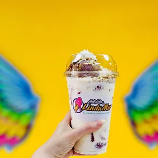 a hand holding a cup of ice cream