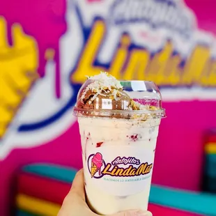 a hand holding a cup of ice cream