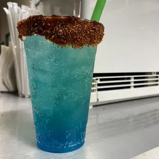 a blue drink with a straw