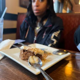 a woman sitting at a table with a plate of food