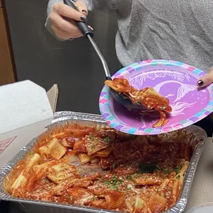 a woman serving a dish of pasta