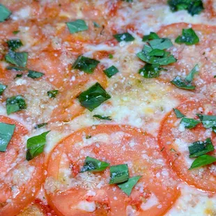 a pizza with tomatoes and basil