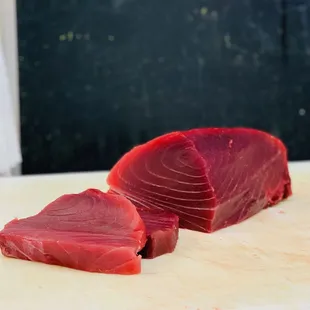 two pieces of raw tuna on a cutting board