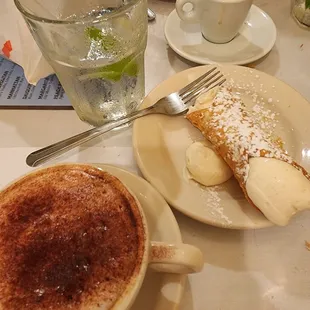 a cup of cappuccino and a plate of pastries