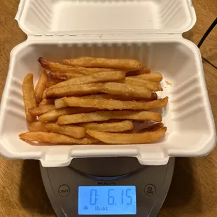 6 oz including the weight of the container. Not exactly 1 lb of fries