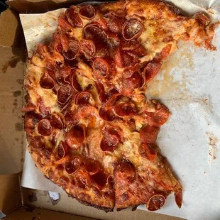 a half eaten pepperoni pizza