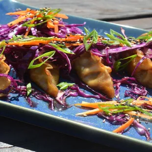 5 Pork potstickers fried on sesame oil, mirin, cabbage, shredded carrots, scallions, sesame seeds, soy sauce, salt &amp; pepper
