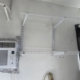 a white wall with shelves and a ceiling fan