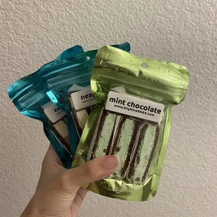 a hand holding a pack of mint chocolate
