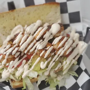 Blackened Shrimp Po&apos;Boy  Blackened shrimp, lettuce, tomato, pickles, and our housemade remoulade sauce on French bread